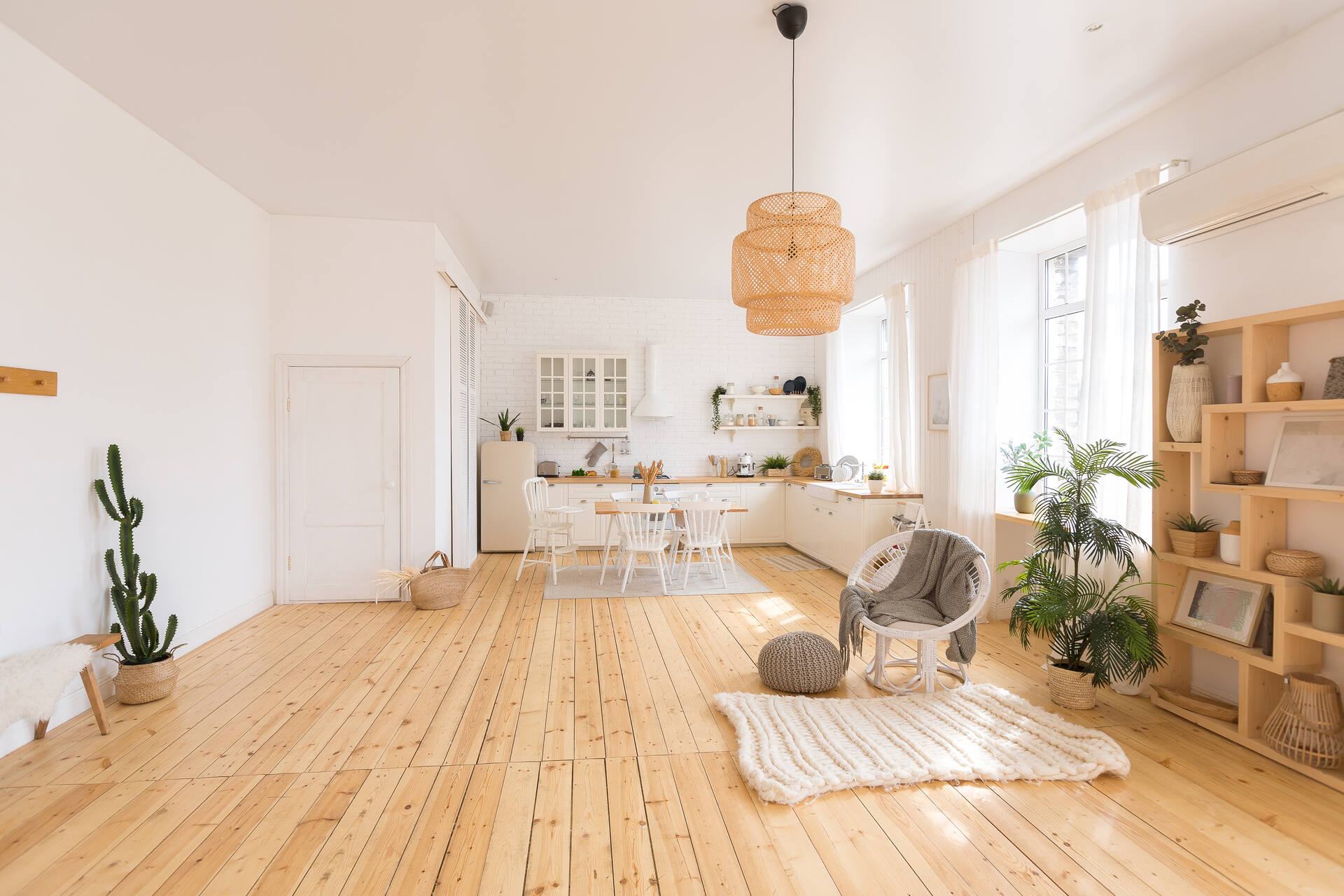 Salón cocina con suelo de madera y muebles blancos